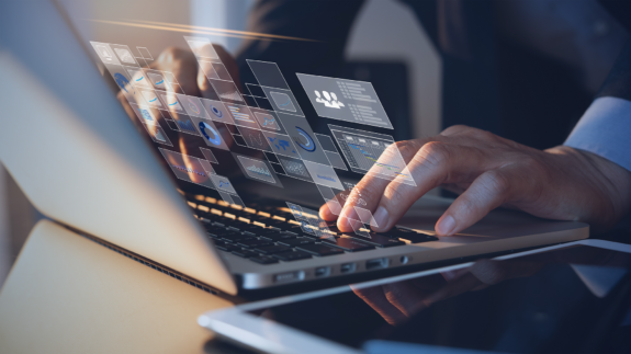 A closeup of a person working on a laptop with technology metrics.